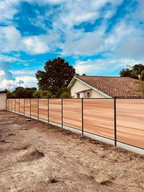 Réalisation d'une clôture en bois composite en coloris Red Cedar avec soubassement ciment à Lège Cap Ferret (33)